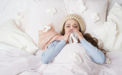 Frau mit Erkältung im Bett